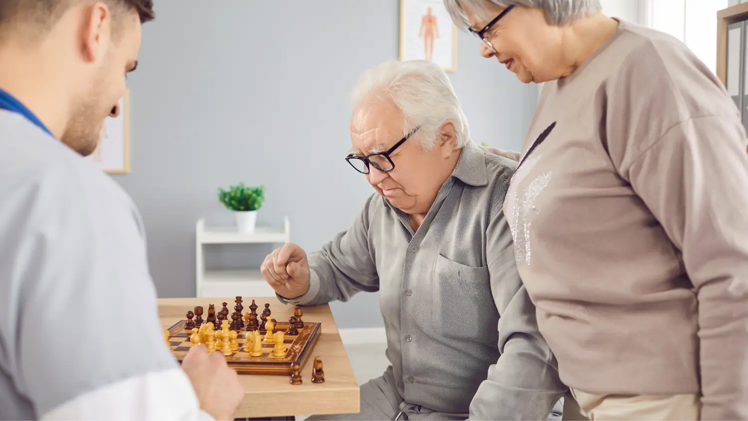 Starejši moški igra šah s podporo žene in krepi kognitivne sposobnosti